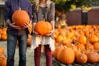 holding pumpkins at pumpkin patch